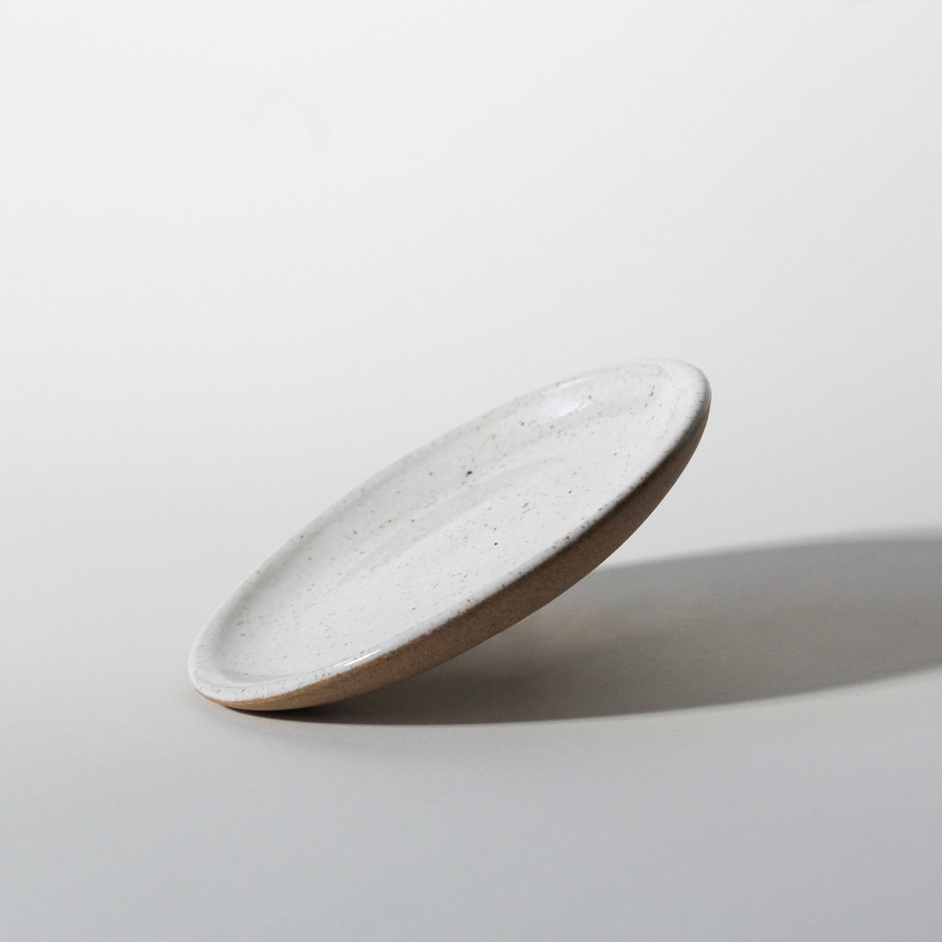 Pires de cerâmica branco Esmo com base em argila tabaco sobre fundo neutro.