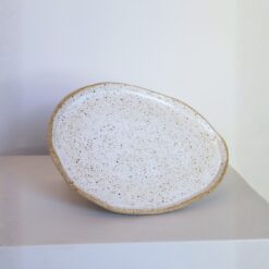 Prato Oval de cerâmica Esmo na cor branca salpicada, com borda em argila tabaco aparente.