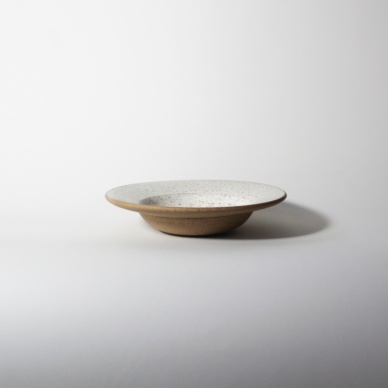 Prato Risoto Esmo de cerâmica com esmalte branco e base em argila tabaco, centralizado.