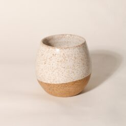 Copo Esmo de cerâmica com design autoral e acabamento em dois tons, argila natural e esmalte branco salpicado.