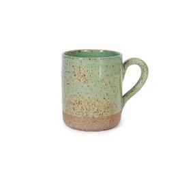 Caneca Reta em Cerâmica Artesanal n na cor Verde Pistache Pistache da Esmo. A peça apresenta um contraste evidente: os dois terços superiores possuem esmalte vitrificado verde suave com um sutil pontilhado orgânico escuro, enquanto a base inferior revela a cerâmica crua com textura rústica e terrosa. Alça esmaltada na lateral direita.