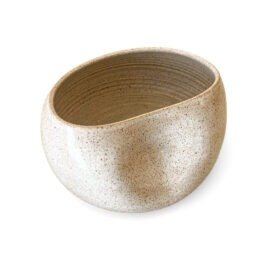 Centro de Mesa Alto Grande na cor Off-White, uma peça de cerâmica artesanal da Esmo. A imagem destaca a silhueta orgânica e assimétrica do objeto, com uma dobra escultórica intencional na lateral direita que cria sombras suaves e valoriza a volumetria da peça. A luz incide sobre o acabamento acetinado e mate, revelando a textura sutilmente salpicada de sua superfície luminosa, limpa e de leitura arquitetônica.