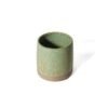 Copo Reto para tomar Café Expresso de cerâmica na cor Pistache da Esmo. A peça de formato cilíndrico e tamanho reduzido possui acabamento superior em esmalte verde suave vitrificado, com finos pontilhados naturais escuros. A faixa da base inferior revela a textura rústica e opaca da argila crua.