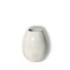 Vaso Oval Pequeno na cor Off-White da Esmo, posicionado centralmente contra um fundo claro que projeta uma sombra suave à direita. A peça de cerâmica artesanal possui uma silhueta curvada com precisão geométrica, destacando-se pelo acabamento acetinado mate que difunde a luz de forma homogênea. A superfície neutra e luminosa apresenta uma textura muito sutil, pontuada por minúsculas manchas escuras orgânicas da própria matéria. A borda superior revela levemente a tonalidade natural e terrosa da cerâmica sob o esmalte.