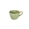 Xícara de café expresso em cerâmica orgânica na cor Pistache da Esmo. A peça possui esmalte vitrificado verde suave com pontilhados escuros naturais, em forte contraste com a base rústica em argila tabaco exposta.