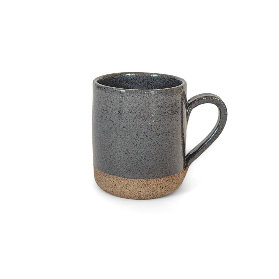 Caneca Reta Cinza da Esmo Cerâmica. Peça utilitária de silhueta reta com alça ergonômica. Possui acabamento esmaltado brilhante em tom escuro pontilhado na parte superior, que forma uma rica oposição de superfícies com a base em cerâmica crua aparente.