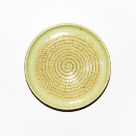 Vista superior do Prato Ralador de cerâmica da Esmo no tom Matcha Latte. Mostra o formato circular com relevo espiralado para triturar alimentos, acabamento brilhante e leitoso com sardas da massa e borda contida em cerâmica.