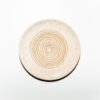 Vista superior do Prato Ralador na cor Off-White, produzido em cerâmica artesanal pela Esmo. A peça circular exibe uma superfície mate acetinada com uma textura sutil de minúsculas pontuações minerais integradas à matéria. No centro, sobressaem-se as ranhuras elevadas em padrão espiral contínuo, onde a luz incidente cria sombras suaves nos relevos cerâmicos, destacando a precisão geométrica e a funcionalidade do design projetado para ralar ingredientes.